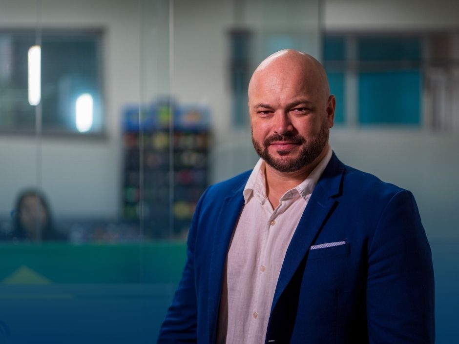 Homem de blazer azul em ambiente de escritório