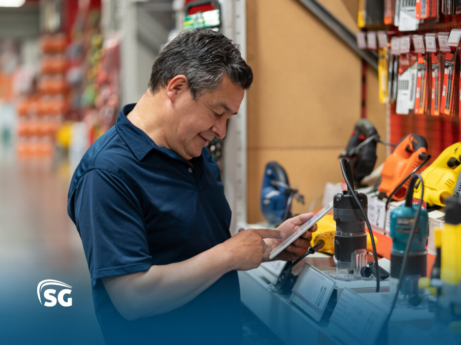 Homem sorridente analisando uma folha em loja de ferramentas