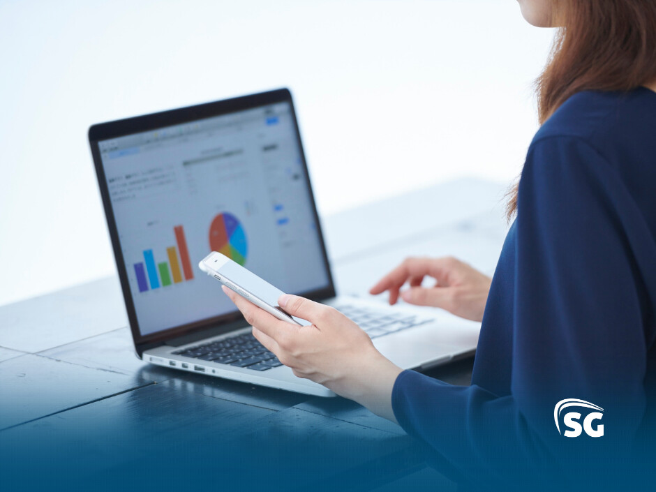 BlogSGSistemas40 Pessoa analisa gráficos em computador e smartphone.