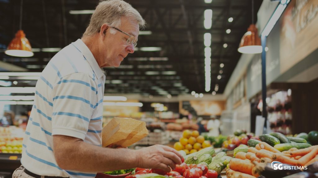RECARREGUEASENERGIAS8 Homem escolhe legumes em mercado.